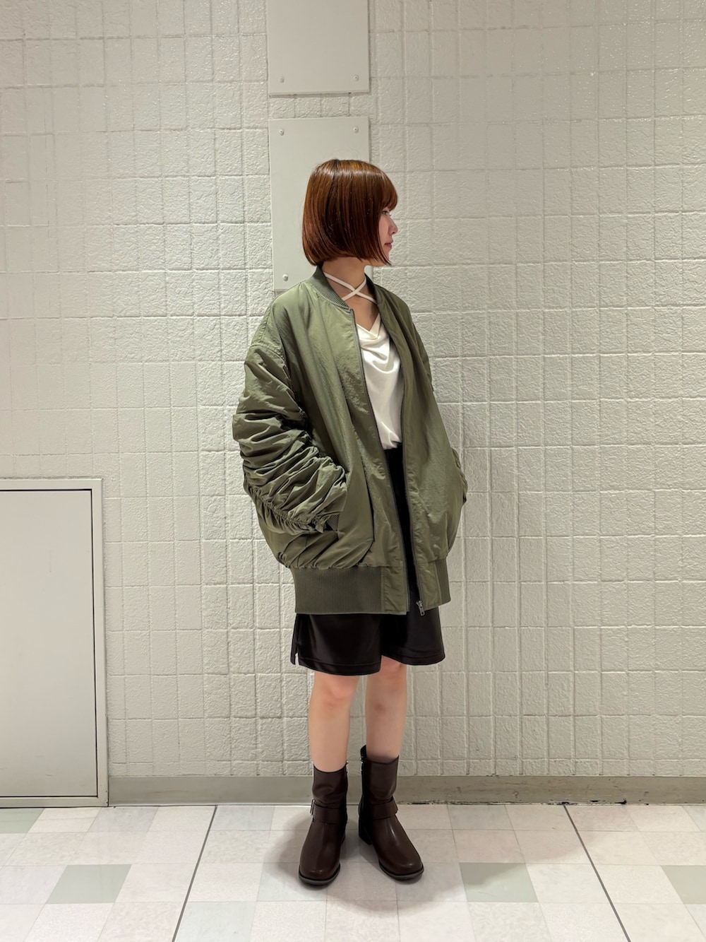 ブラウン系のその他パンツ、ブラウン系のブーツ、ホワイト系のTシャツ/カットソーを着用したレディースの秋コーディネートの3枚目の写真