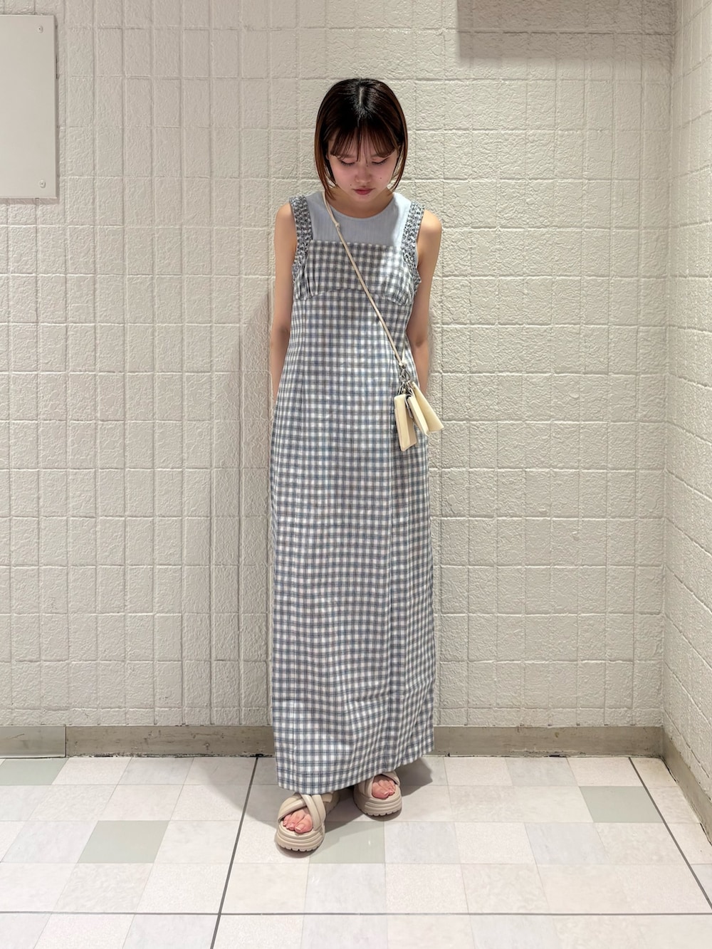 ホワイト系のタンクトップ、ホワイト系のワンピース、ホワイト系のポーチを着用したレディースの夏コーディネートの3枚目の写真