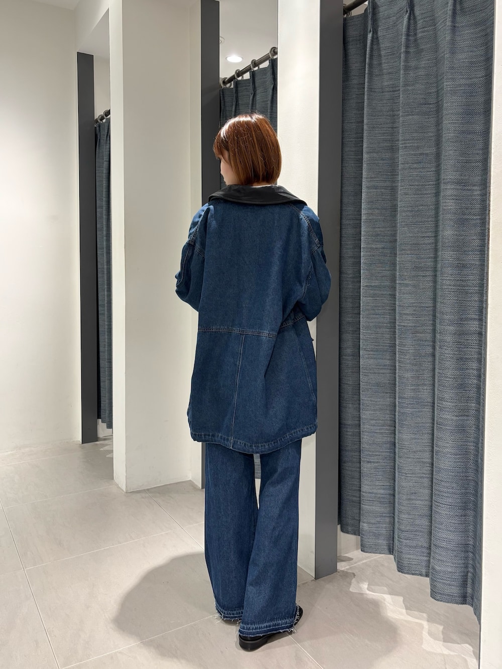 ブルー系のカバーオール、ブルー系のデニムパンツ、ブラック系のローファーを着用したレディースの秋コーディネートの3枚目の写真