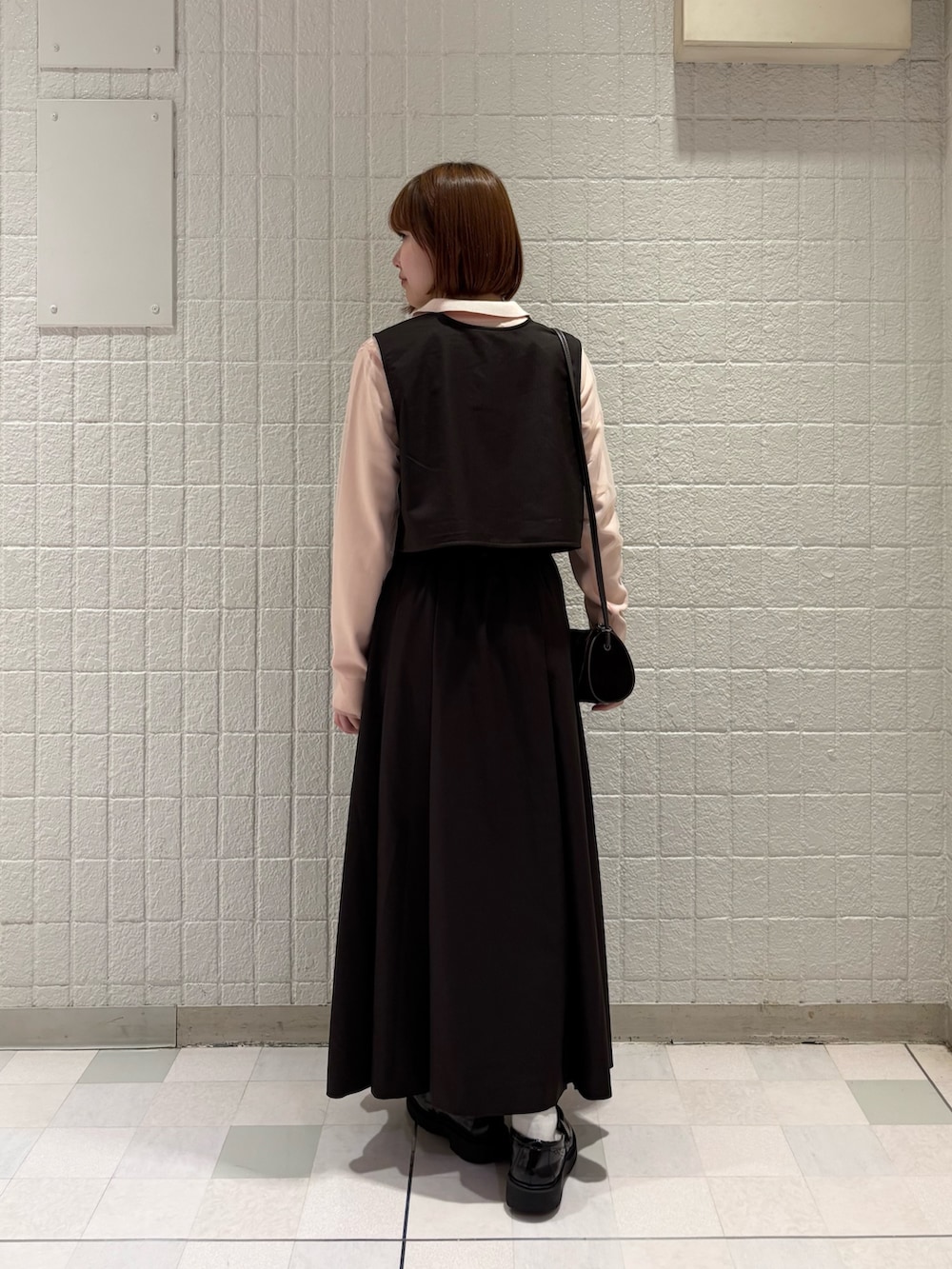 ピンク系のニット/セーター、ブラウン系のショルダーバッグ、ブラウン系のワンピースを着用したレディースの秋コーディネートの2枚目の写真