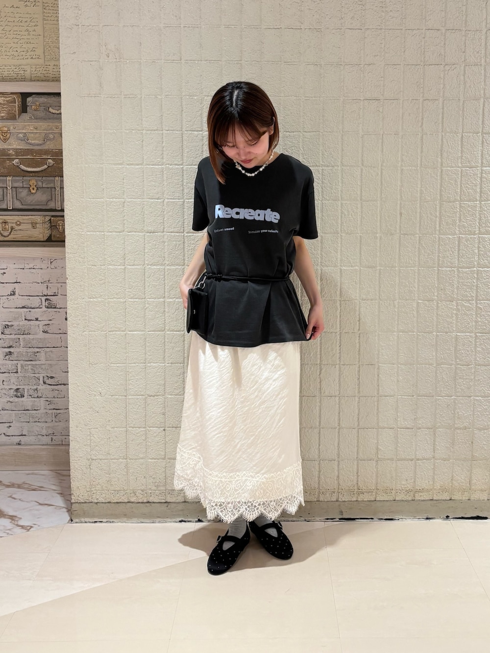 グレー系のTシャツ/カットソー、ホワイト系のスカート、ブラック系のバレエシューズを着用したレディースの夏コーディネートの4枚目の写真