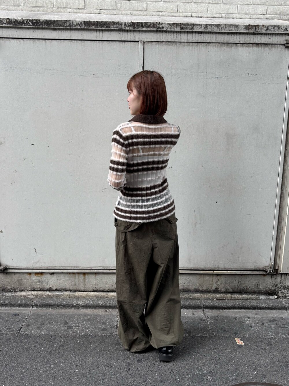 ブラウン系のニット/セーター、グリーン系のその他パンツを着用したレディースの秋コーディネートの3枚目の写真