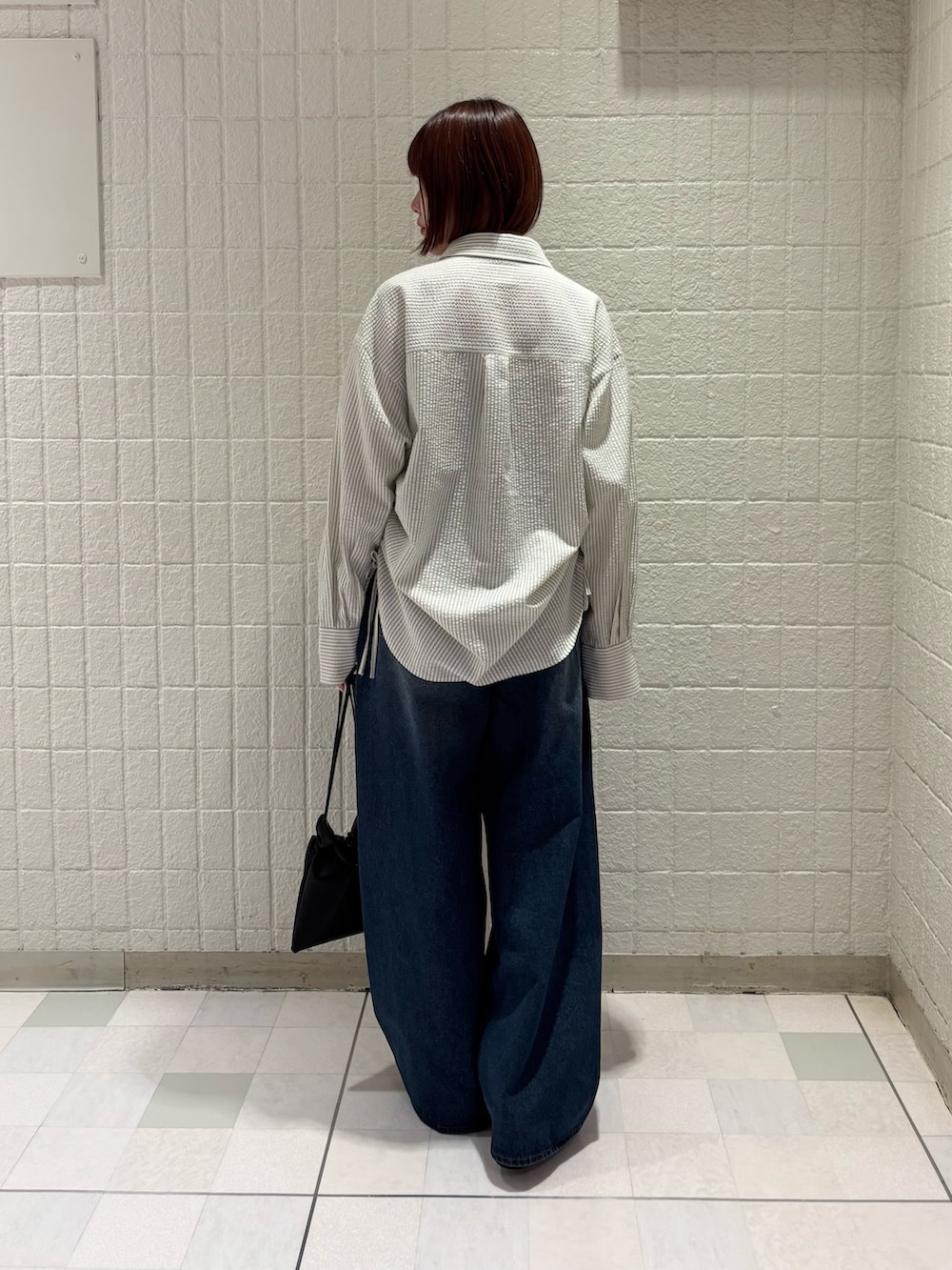 ブラック系のその他シューズ、ブラック系のショルダーバッグ、ブルー系のデニムパンツを着用したレディースの春コーディネートの3枚目の写真