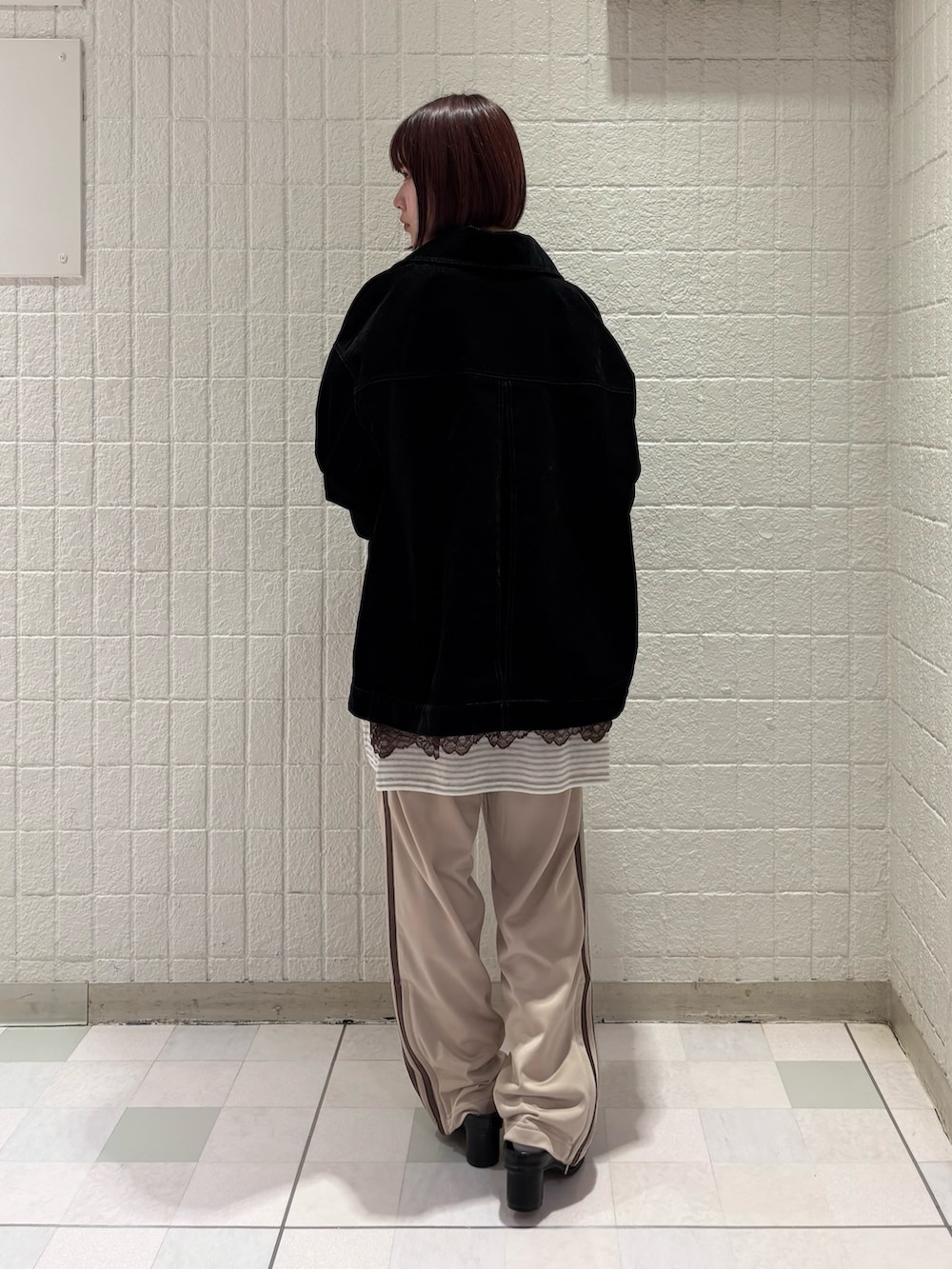 ホワイト系のニット/セーター、ブラック系のブルゾン、ブラウン系のキャミソールを着用したレディースの春コーディネートの3枚目の写真