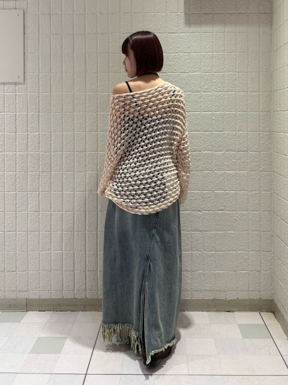 ホワイト系のニット/セーター、ブラウン系のショルダーバッグ、ブラック系のスカートを着用したレディースの春コーディネートの3枚目の写真