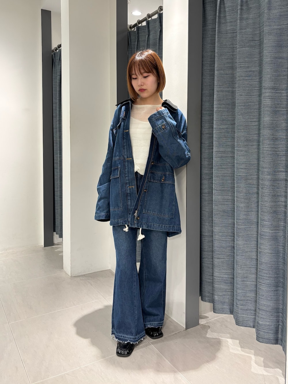 ブルー系のカバーオール、ブルー系のデニムパンツ、ブラック系のローファーを着用したレディースの秋コーディネートの4枚目の写真