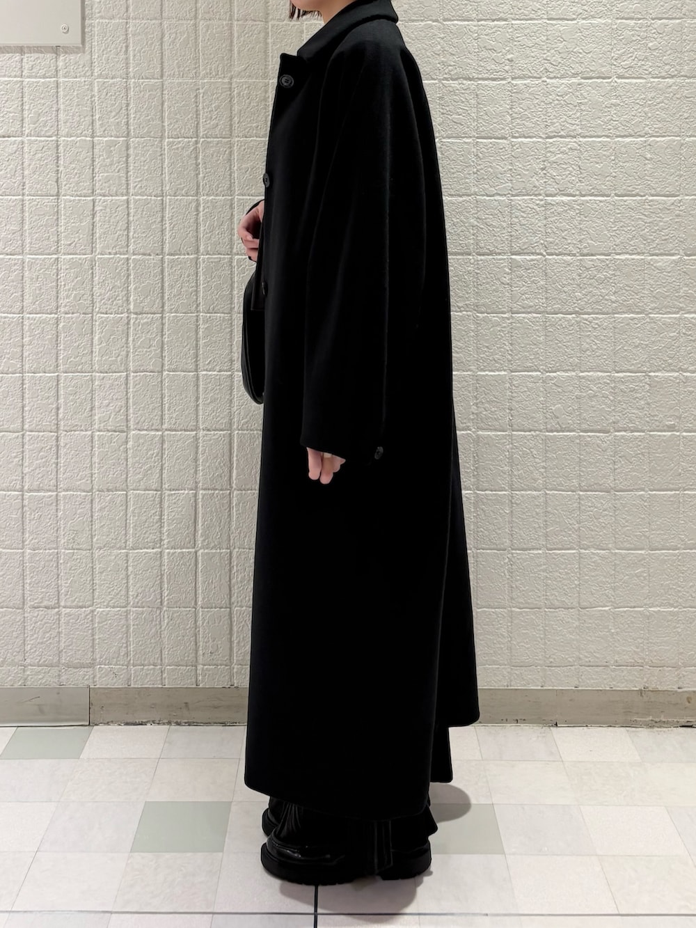 ピンク系のTシャツ/カットソー、ブラック系のステンカラーコート、ブラウン系のワンピースを着用したレディースの冬コーディネートの2枚目の写真