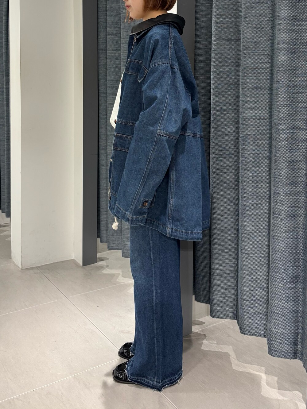 ブルー系のカバーオール、ブルー系のデニムパンツ、ブラック系のローファーを着用したレディースの秋コーディネートの2枚目の写真