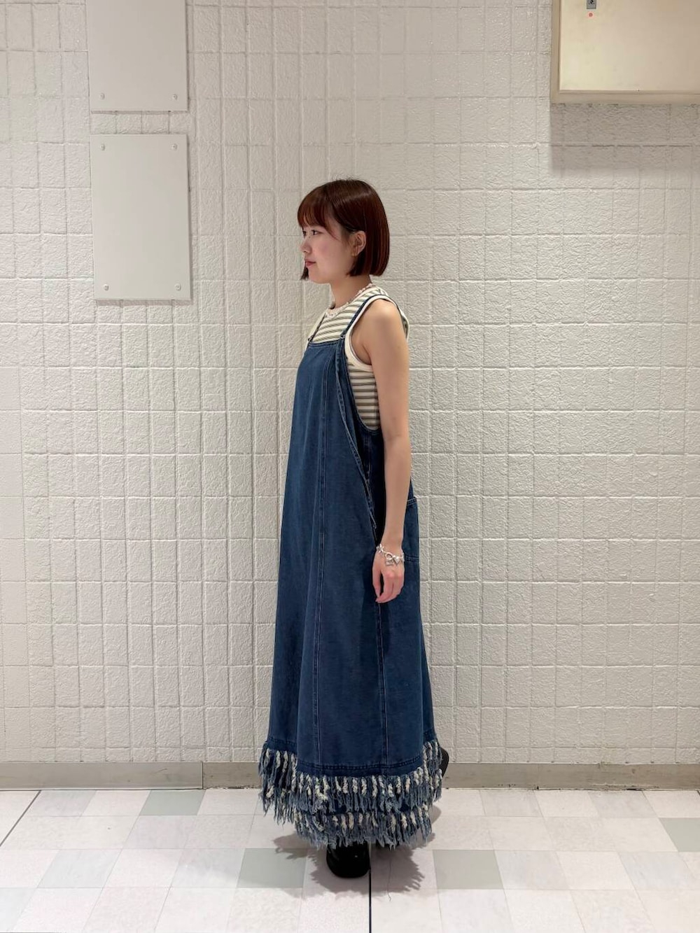 ホワイト系のタンクトップ、ブラック系のスニーカー、ブルー系のワンピースを着用したレディースの夏コーディネートの3枚目の写真