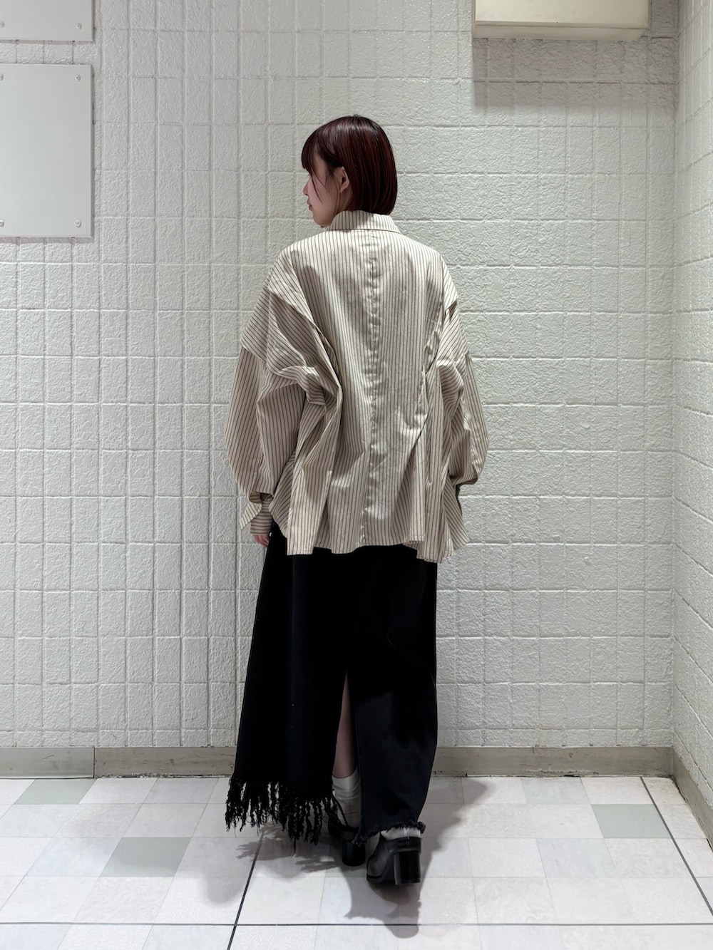 ベージュ系のシャツ/ブラウス、ブラック系のスカート、ブラック系のサンダルを着用したレディースの冬コーディネートの2枚目の写真