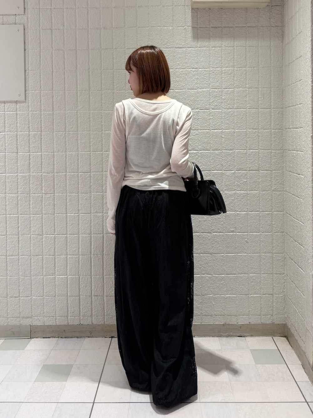 ホワイト系のTシャツ/カットソー、ブラック系のその他パンツ、ブラック系のボストンバッグを着用したレディースの春コーディネートの3枚目の写真