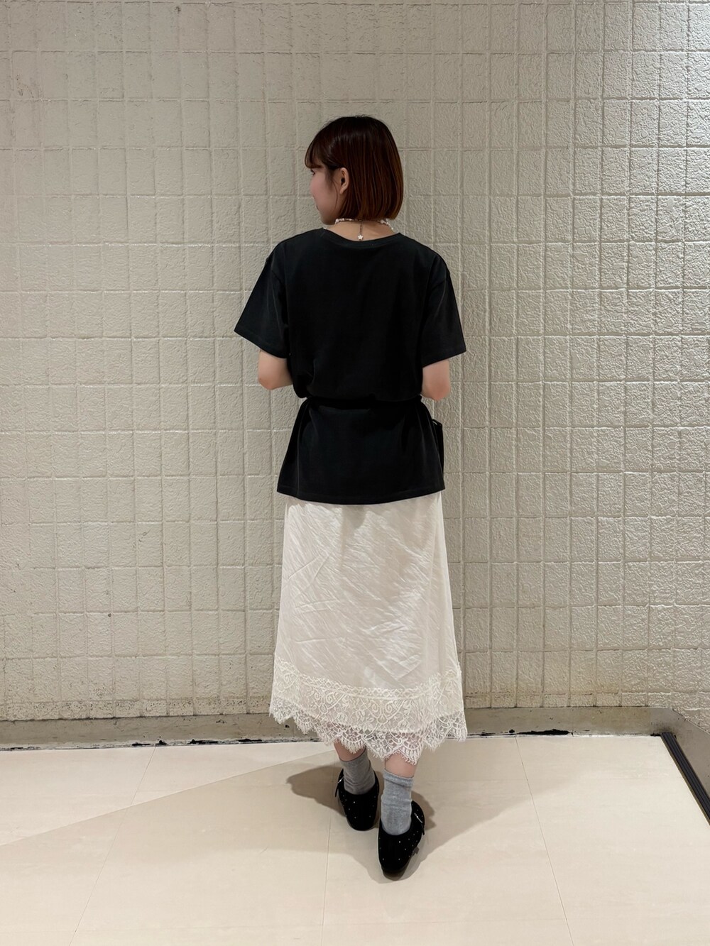 グレー系のTシャツ/カットソー、ホワイト系のスカート、ブラック系のバレエシューズを着用したレディースの夏コーディネートの3枚目の写真