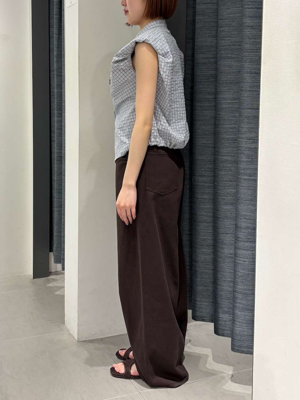 ブラウン系のサンダル、ブラウン系のその他パンツ、ブルー系のシャツ/ブラウスを着用したレディースの夏コーディネートの2枚目の写真