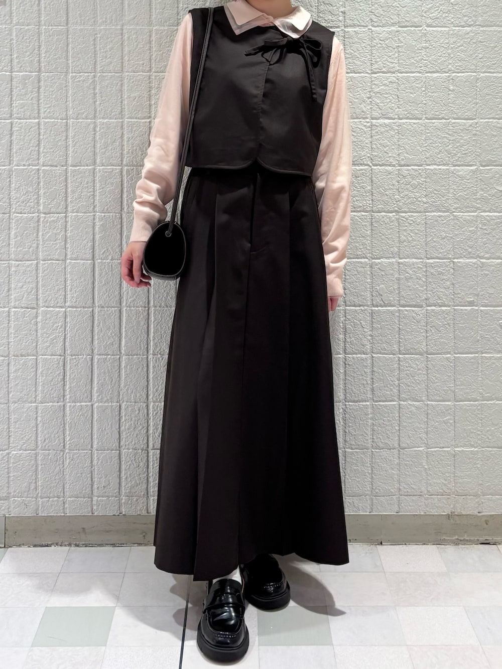 ピンク系のニット/セーター、ブラウン系のショルダーバッグ、ブラウン系のワンピースを着用したレディースの秋コーディネートの3枚目の写真