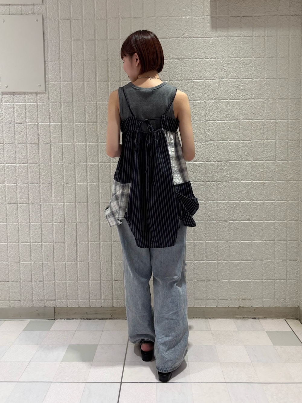 グレー系のタンクトップ、ブルー系のワンピース、ブルー系のデニムパンツを着用したレディースの夏コーディネートの2枚目の写真