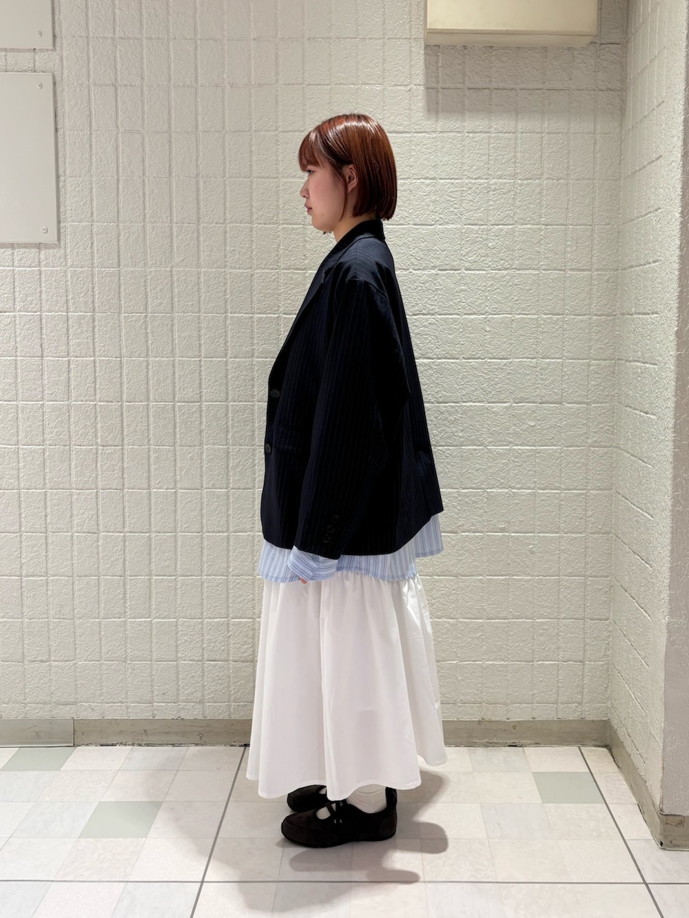 ブラウン系のTシャツ/カットソー、ブルー系のその他アウター、ホワイト系のスカートを着用したレディースの冬コーディネートの2枚目の写真