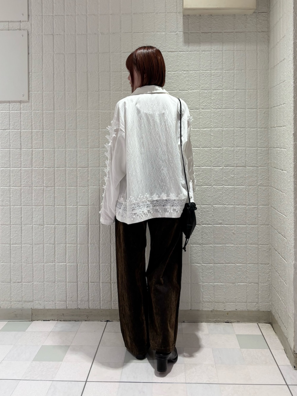 ホワイト系のシャツ/ブラウス、ブラック系のサンダル、ブラック系のショルダーバッグを着用したレディースの冬コーディネートの3枚目の写真