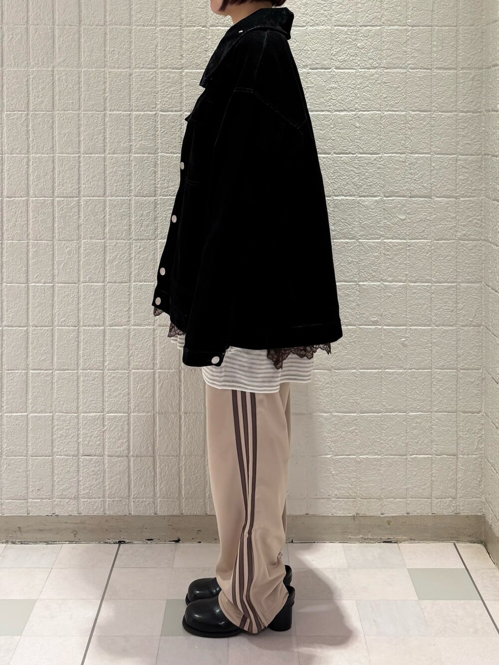 ホワイト系のニット/セーター、ブラック系のブルゾン、ブラウン系のキャミソールを着用したレディースの春コーディネートの2枚目の写真