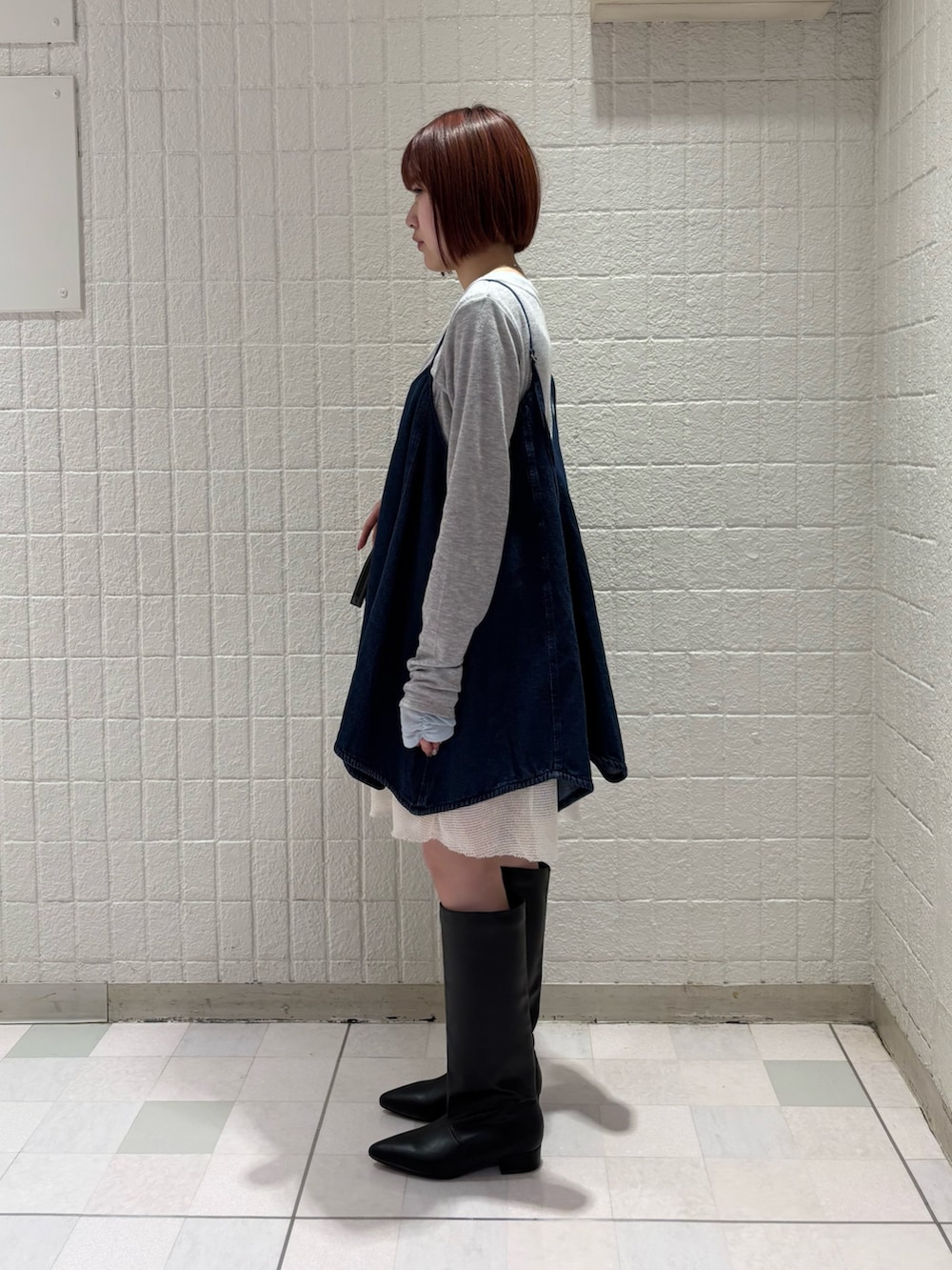 グレー系のTシャツ/カットソー、ブルー系のワンピース、ブラック系のボストンバッグを着用したレディースの冬コーディネートの2枚目の写真