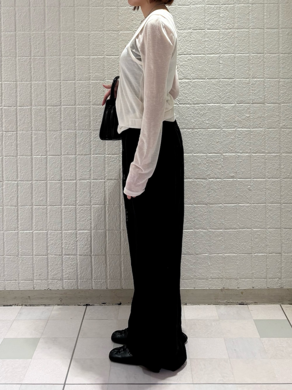 ホワイト系のTシャツ/カットソー、ブラック系のその他パンツ、ブラック系のボストンバッグを着用したレディースの春コーディネートの2枚目の写真