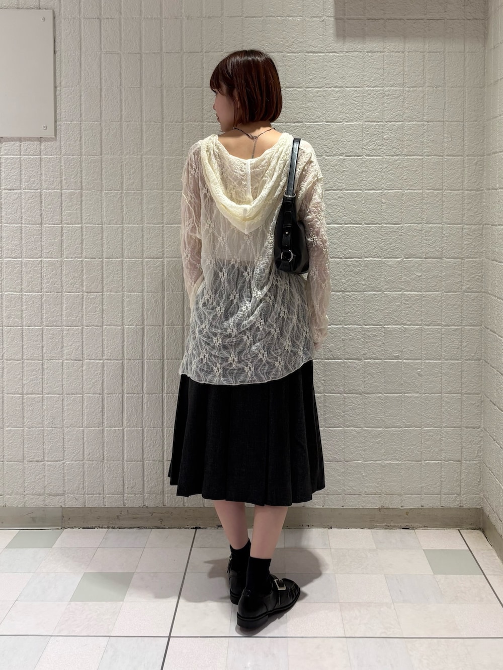 ブラック系のショルダーバッグ、ホワイト系のTシャツ/カットソー、グレー系のスカートを着用したレディースの夏コーディネートの3枚目の写真