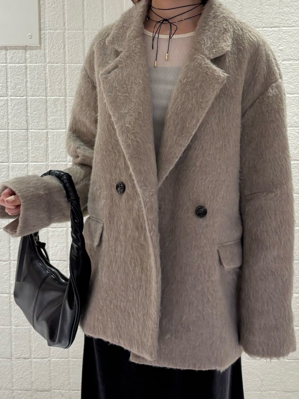 ブラウン系のその他アウター、ブラック系のハンドバッグ、グレー系のスカートを着用したレディースの秋コーディネートの4枚目の写真