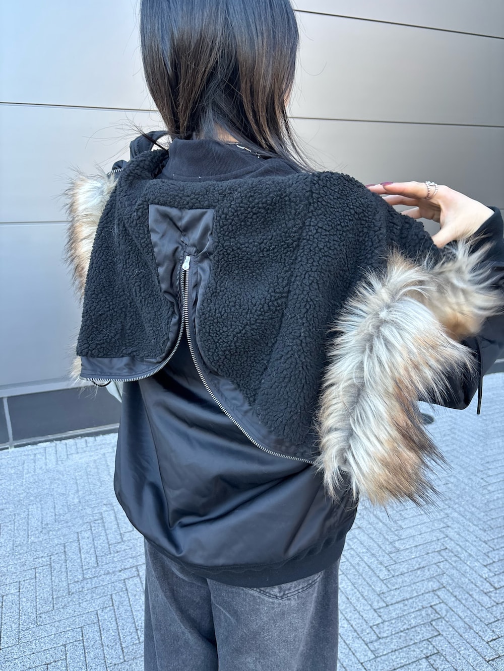 ブラック系のその他アウター、ブラック系のTシャツ/カットソー、ブラック系のデニムパンツを着用したレディースの冬コーディネートの2枚目の写真