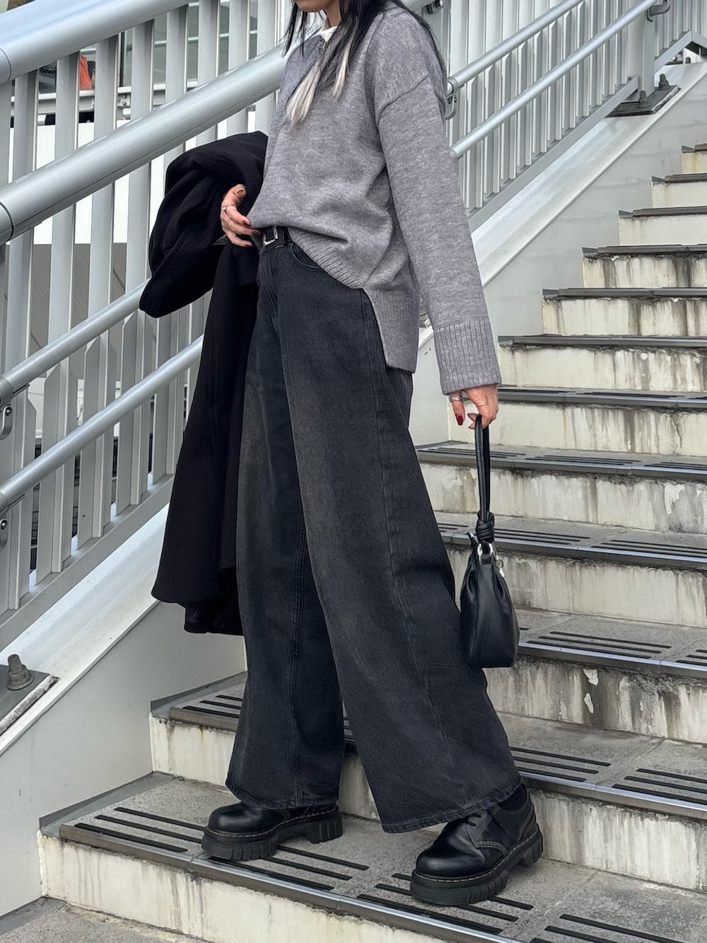 ブラック系のチェスターコート、ホワイト系のTシャツ/カットソー、グレー系のニット/セーターを着用したレディースの冬コーディネートの4枚目の写真