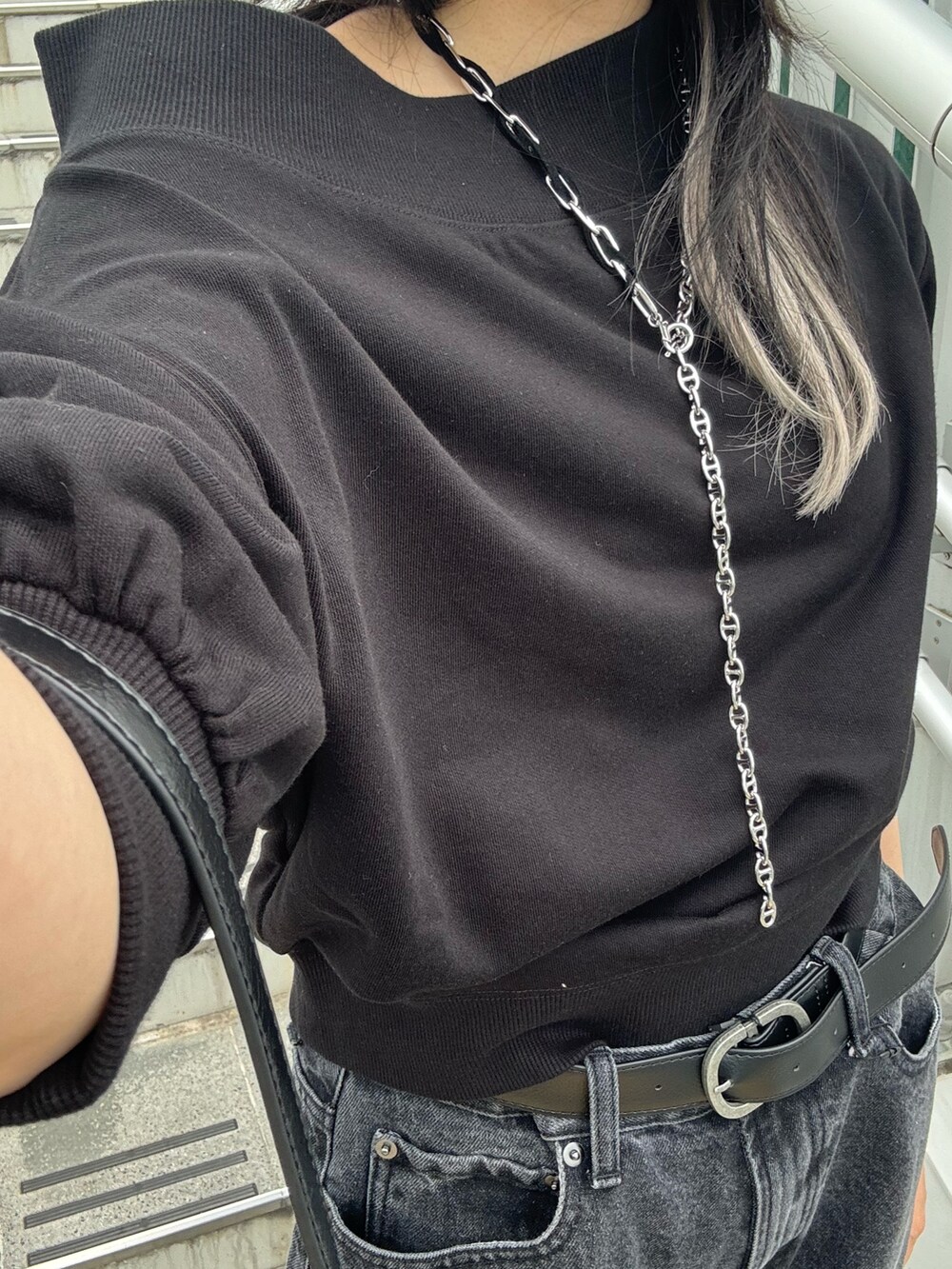 ブラック系のスウェット、ブラック系のデニムパンツ、ブラック系のハンドバッグを着用したレディースの夏コーディネートの3枚目の写真
