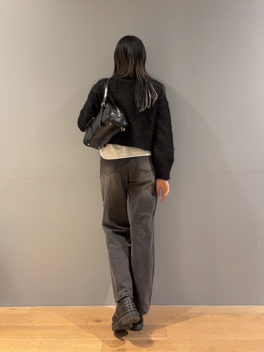 ブラック系のカーディガン/ボレロ、ホワイト系のTシャツ/カットソー、ブラック系のデニムパンツを着用したレディースの冬コーディネートの3枚目の写真