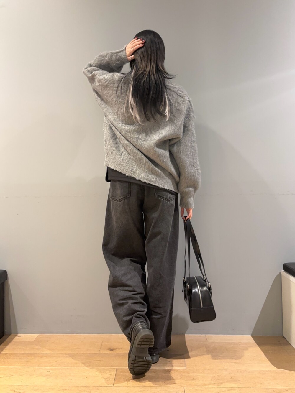 グレー系のカーディガン/ボレロ、ブラック系のTシャツ/カットソー、ブラック系のデニムパンツを着用したレディースの冬コーディネートの2枚目の写真