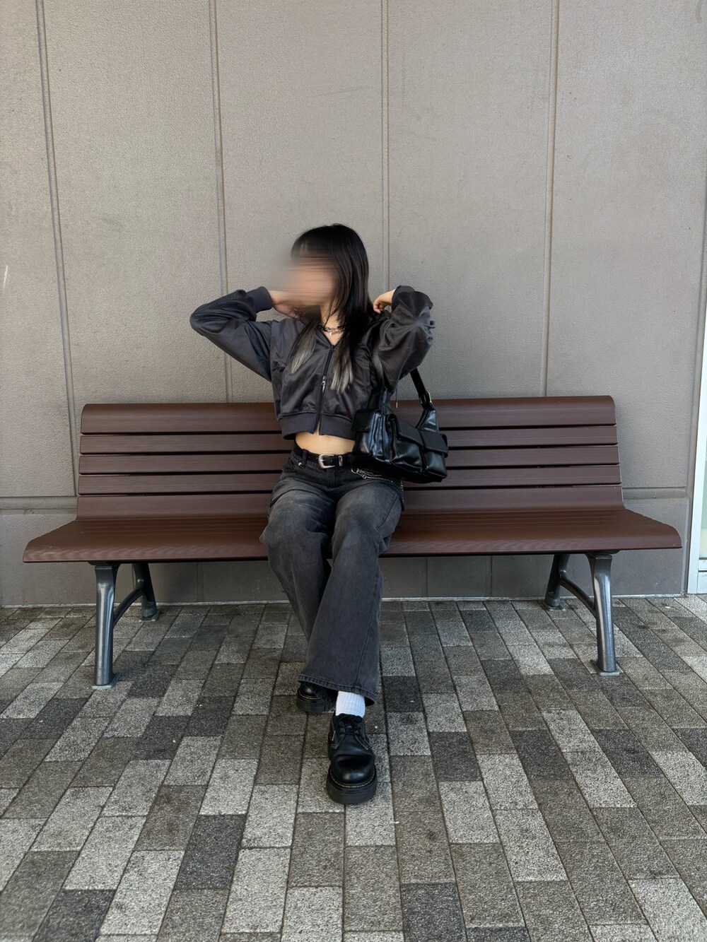 グレー系のパーカー、ブラック系のデニムパンツ、ブラック系のショルダーバッグを着用したレディースの秋コーディネートの3枚目の写真