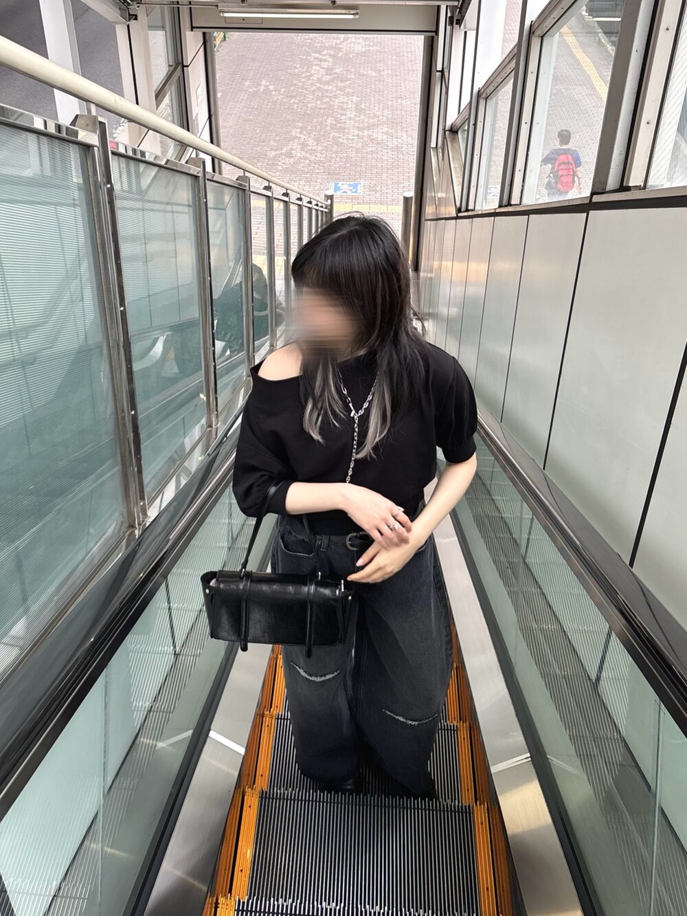 ブラック系のスウェット、ブラック系のデニムパンツ、ブラック系のハンドバッグを着用したレディースの夏コーディネートの2枚目の写真