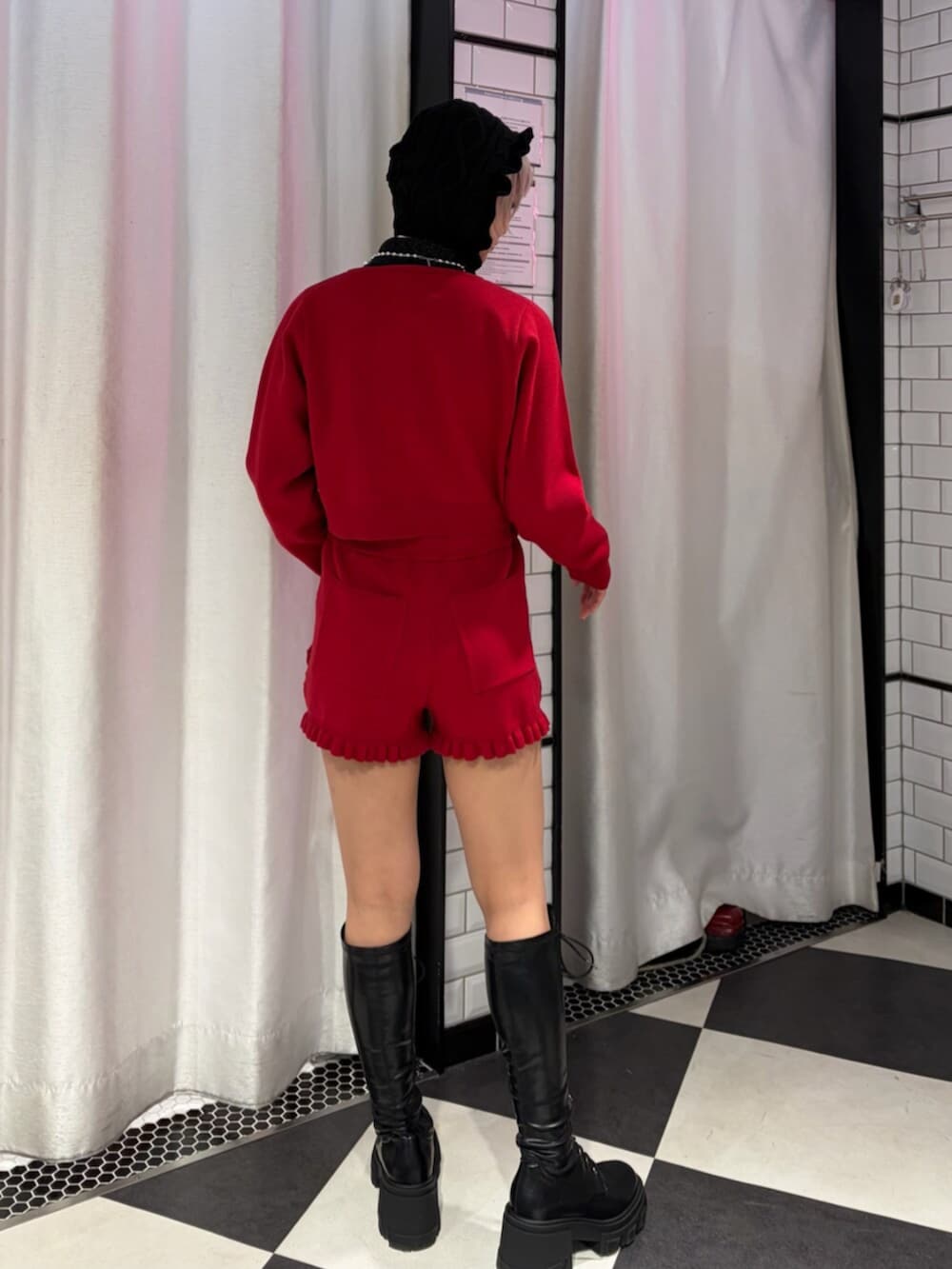 ブラック系のブーツ、レッド系のニット/セーター、レッド系のその他パンツを着用したレディースの冬コーディネートの3枚目の写真