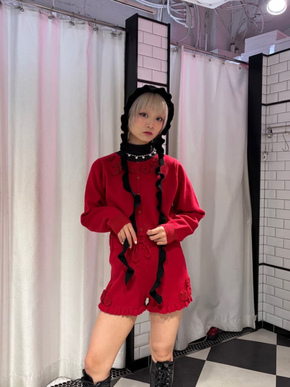 ブラック系のブーツ、レッド系のニット/セーター、レッド系のその他パンツを着用したレディースの冬コーディネートの5枚目の写真