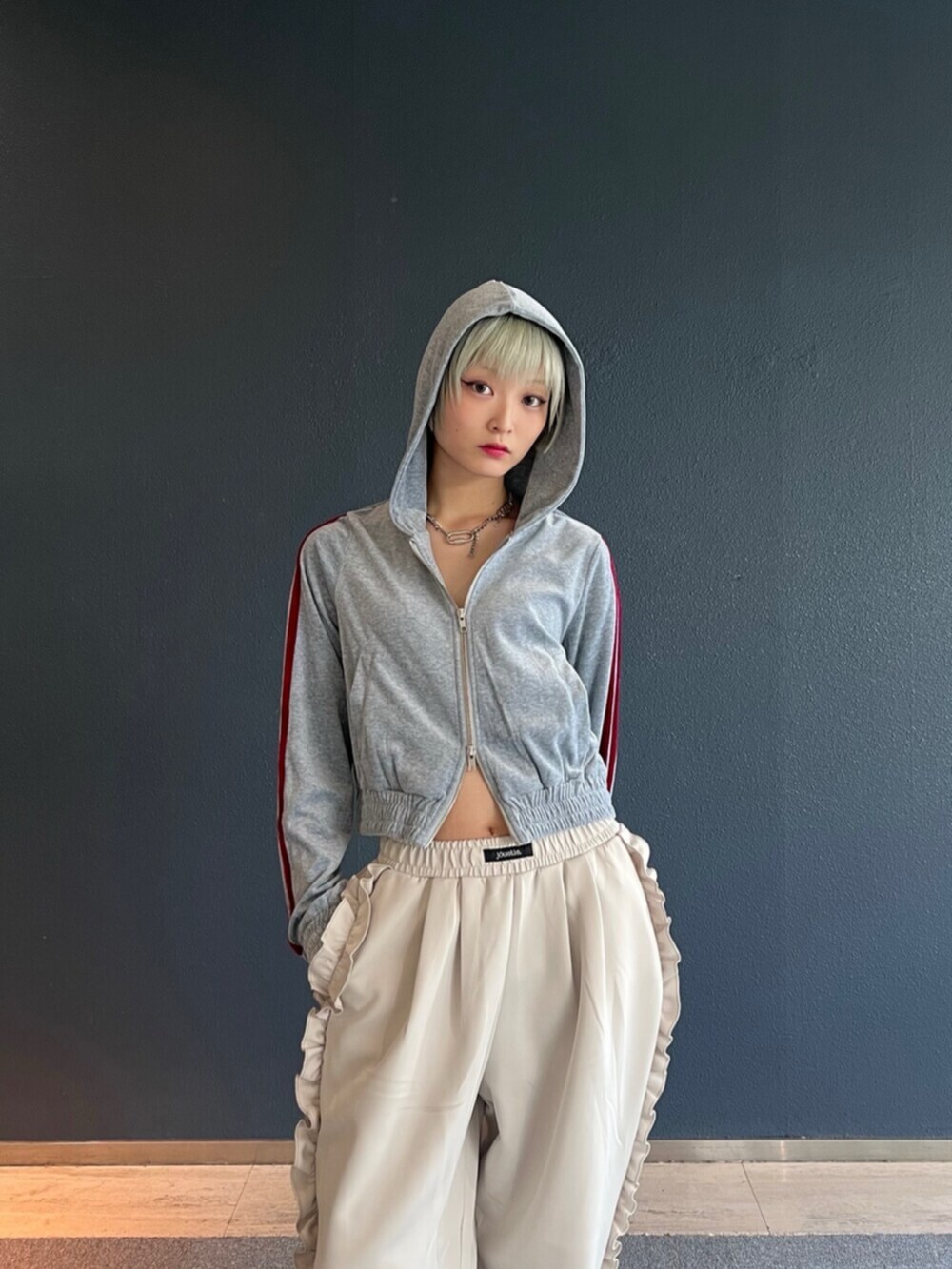 グレー系のパーカー、ホワイト系のその他パンツを着用したレディースの秋コーディネートの5枚目の写真