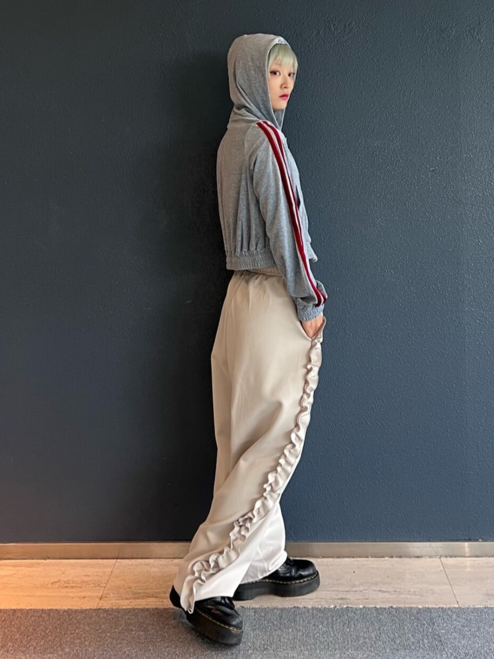 グレー系のパーカー、ホワイト系のその他パンツを着用したレディースの秋コーディネートの2枚目の写真