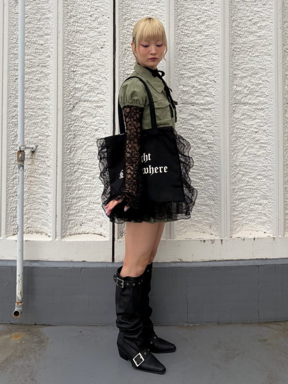 ブラック系のTシャツ/カットソー、ブラック系のブーツ、グリーン系のワンピースを着用したレディースの春コーディネートの3枚目の写真