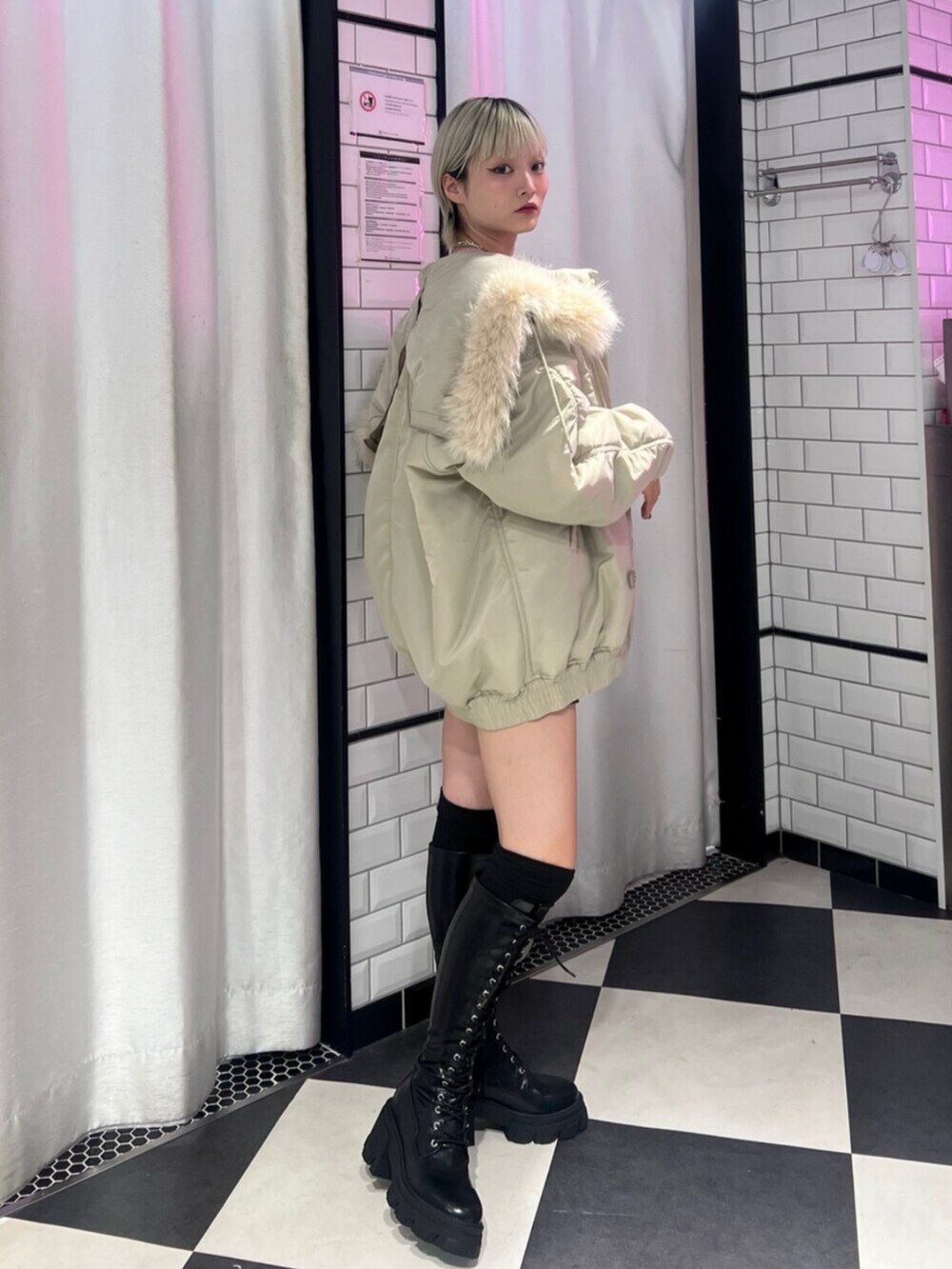 ブラック系のブーツ、ホワイト系のブルゾン、グレー系のニット/セーターを着用したレディースの秋コーディネートの3枚目の写真