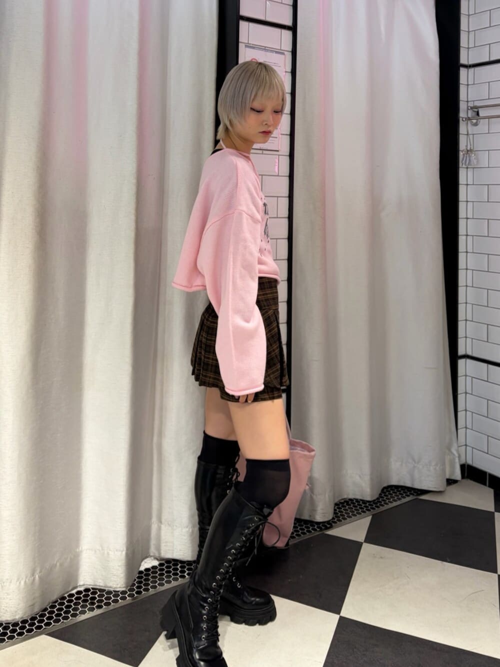 ブラック系のブーツ、ブラウン系のスカート、ピンク系のニット/セーターを着用したレディースの秋コーディネートの2枚目の写真