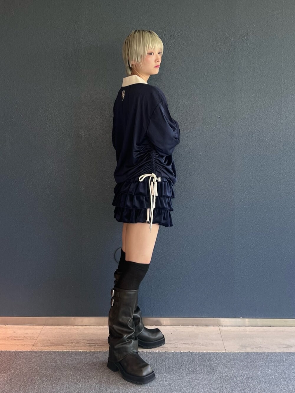 ブルー系のスカート、ブラック系のブーツ、ブルー系のTシャツ/カットソーを着用したレディースの秋コーディネートの2枚目の写真