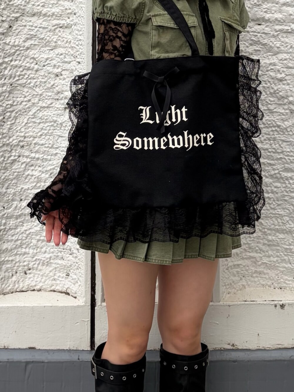 ブラック系のTシャツ/カットソー、ブラック系のブーツ、グリーン系のワンピースを着用したレディースの春コーディネートの6枚目の写真