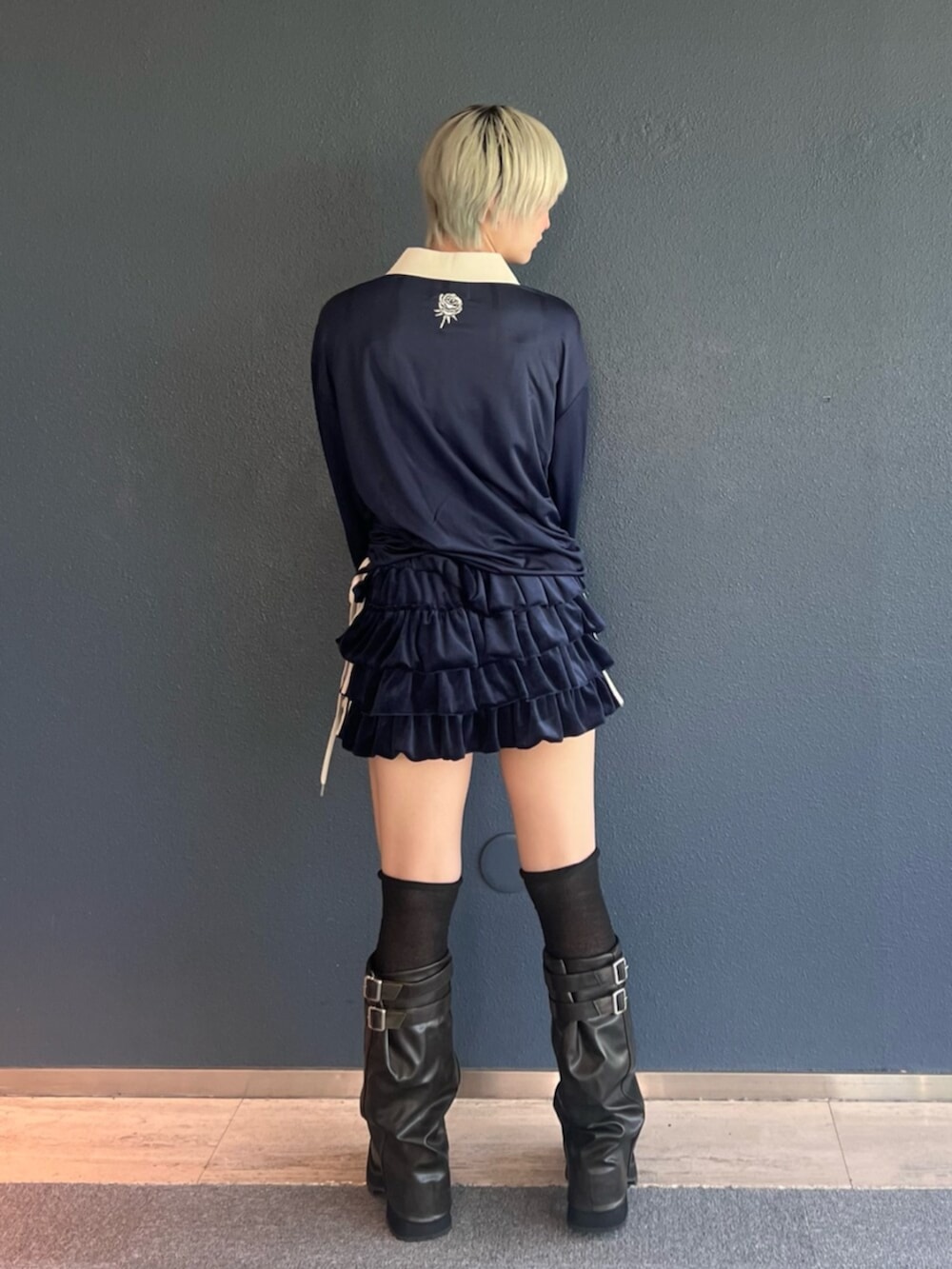 ブルー系のスカート、ブラック系のブーツ、ブルー系のTシャツ/カットソーを着用したレディースの秋コーディネートの3枚目の写真