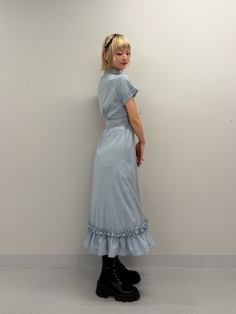 ブルー系のワンピース、ブラック系のブーツを着用したレディースの春コーディネートの2枚目の写真