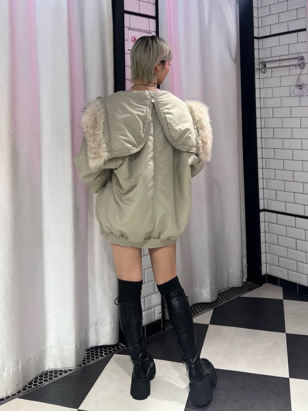 ブラック系のブーツ、ホワイト系のブルゾン、グレー系のニット/セーターを着用したレディースの秋コーディネートの4枚目の写真