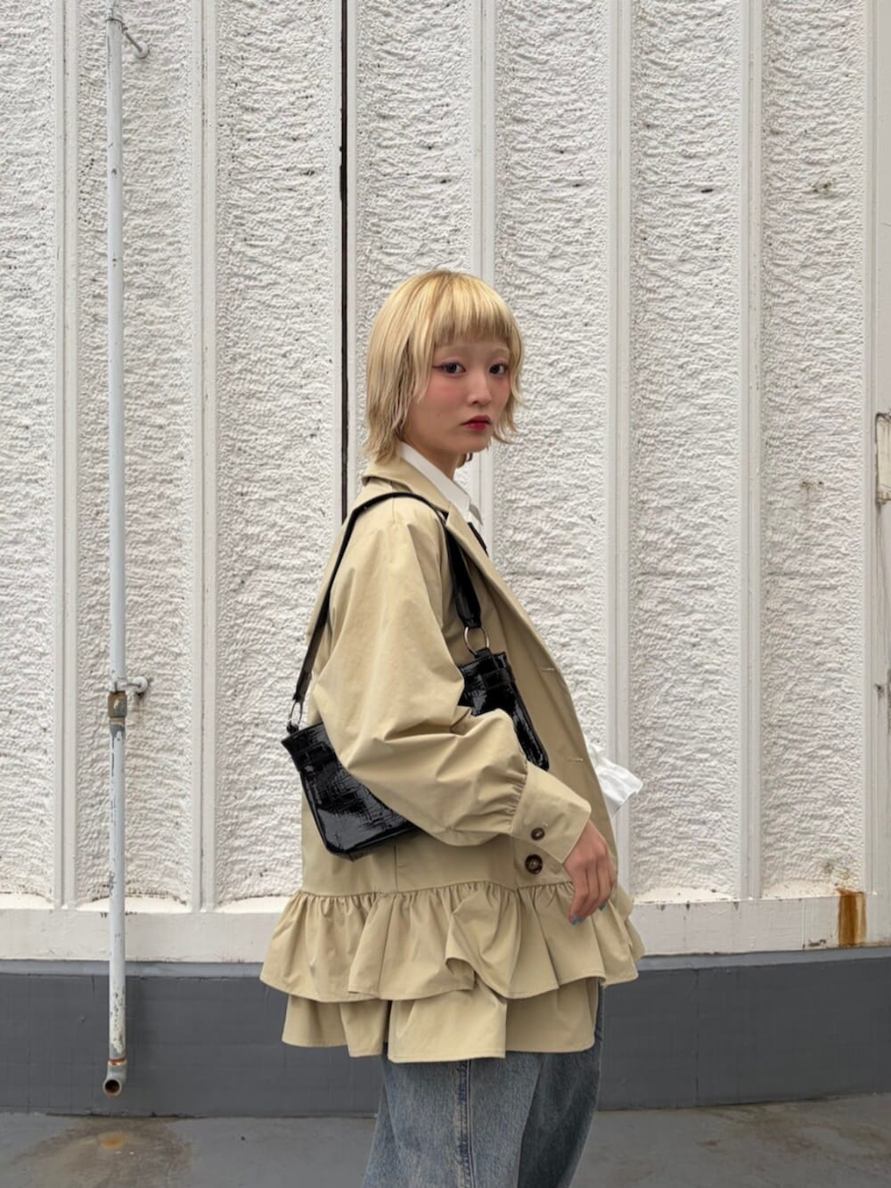 ブラック系のハンドバッグ、ブラック系のネクタイ、ブラック系のローファーを着用したレディースの冬コーディネートの4枚目の写真