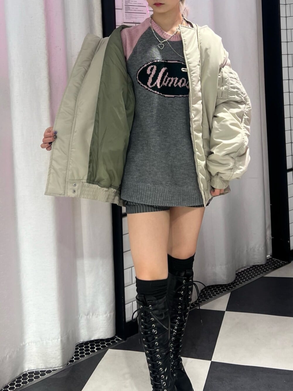 ブラック系のブーツ、ホワイト系のブルゾン、グレー系のニット/セーターを着用したレディースの秋コーディネートの5枚目の写真