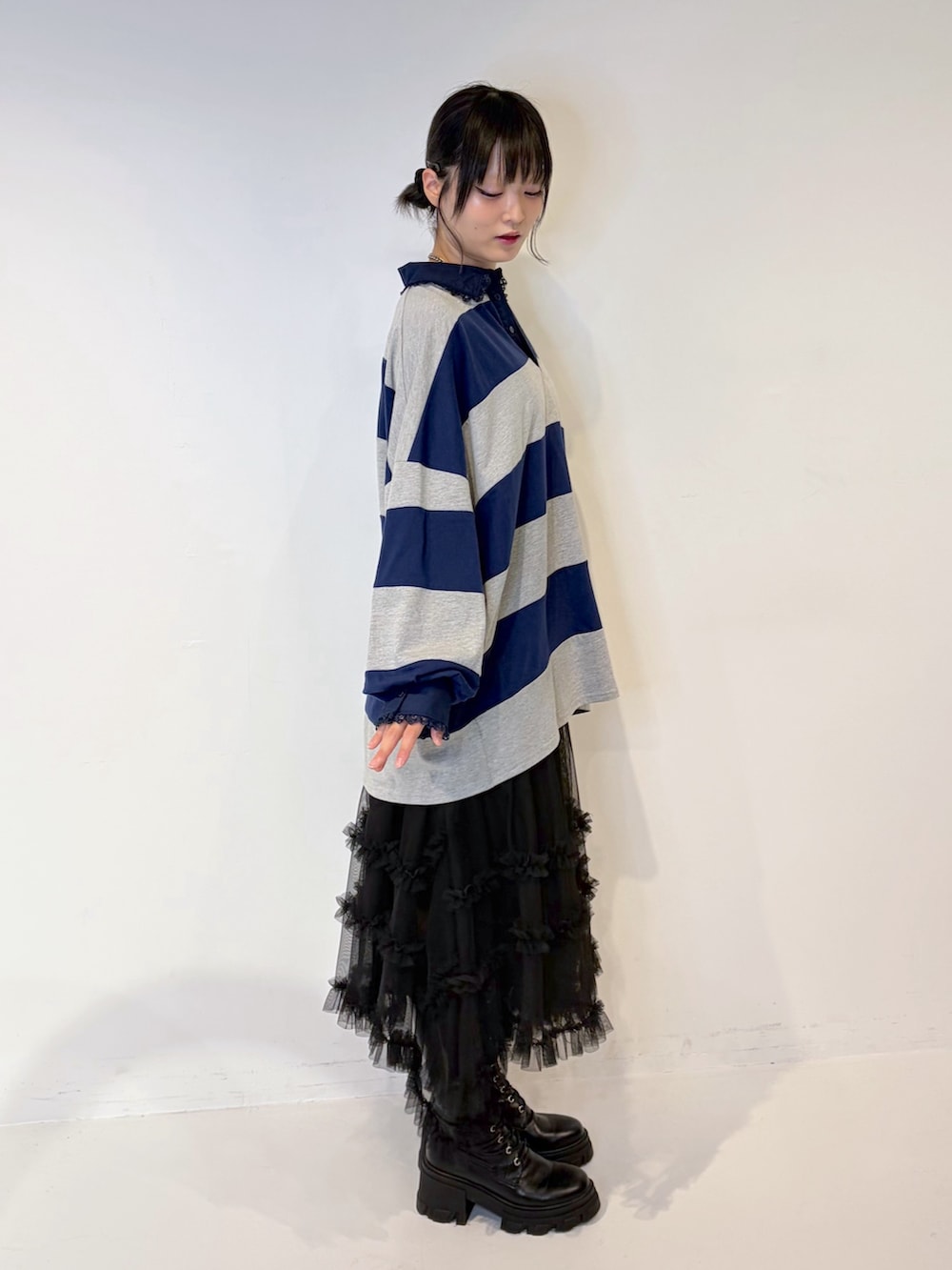 グレー系のTシャツ/カットソー、ブラック系のスカート、ブラック系のブーツを着用したレディースの夏コーディネートの2枚目の写真
