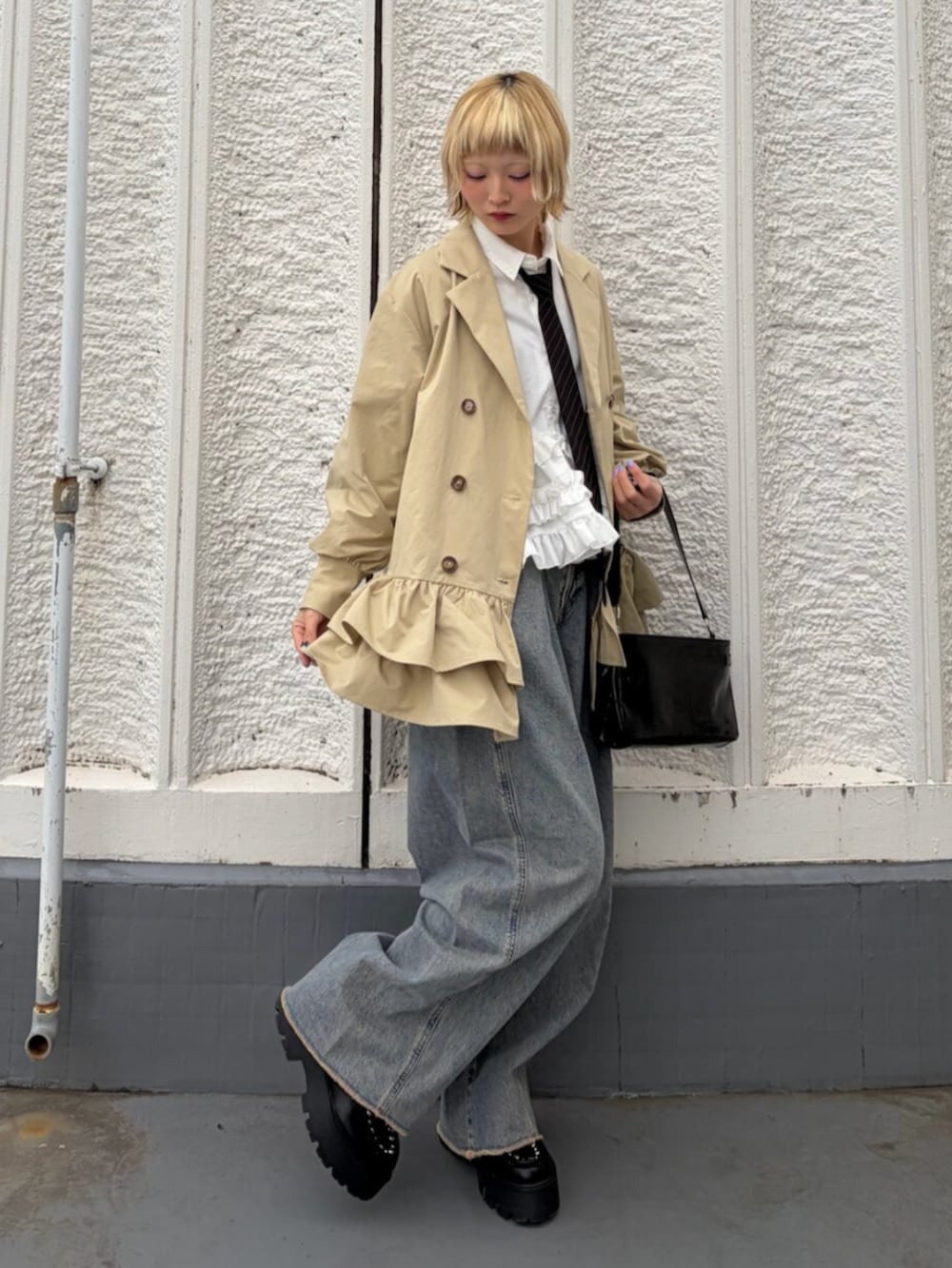 ブラック系のハンドバッグ、ブラック系のネクタイ、ブラック系のローファーを着用したレディースの冬コーディネートの2枚目の写真