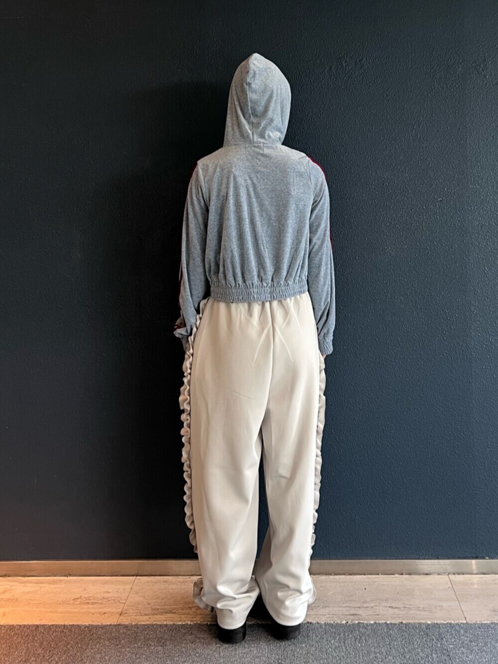 グレー系のパーカー、ホワイト系のその他パンツを着用したレディースの秋コーディネートの3枚目の写真